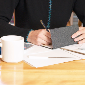 An individual writing a check as  the first part of a matching gift program