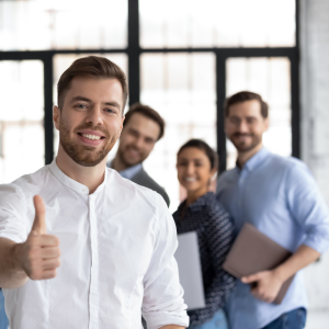 Employees smiling and giving the thumbs up  showing increased moral as part of matching gifts programs
